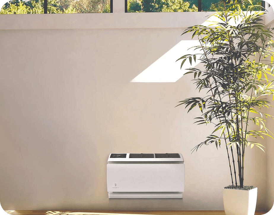 A white air conditioner sitting in front of a wall.